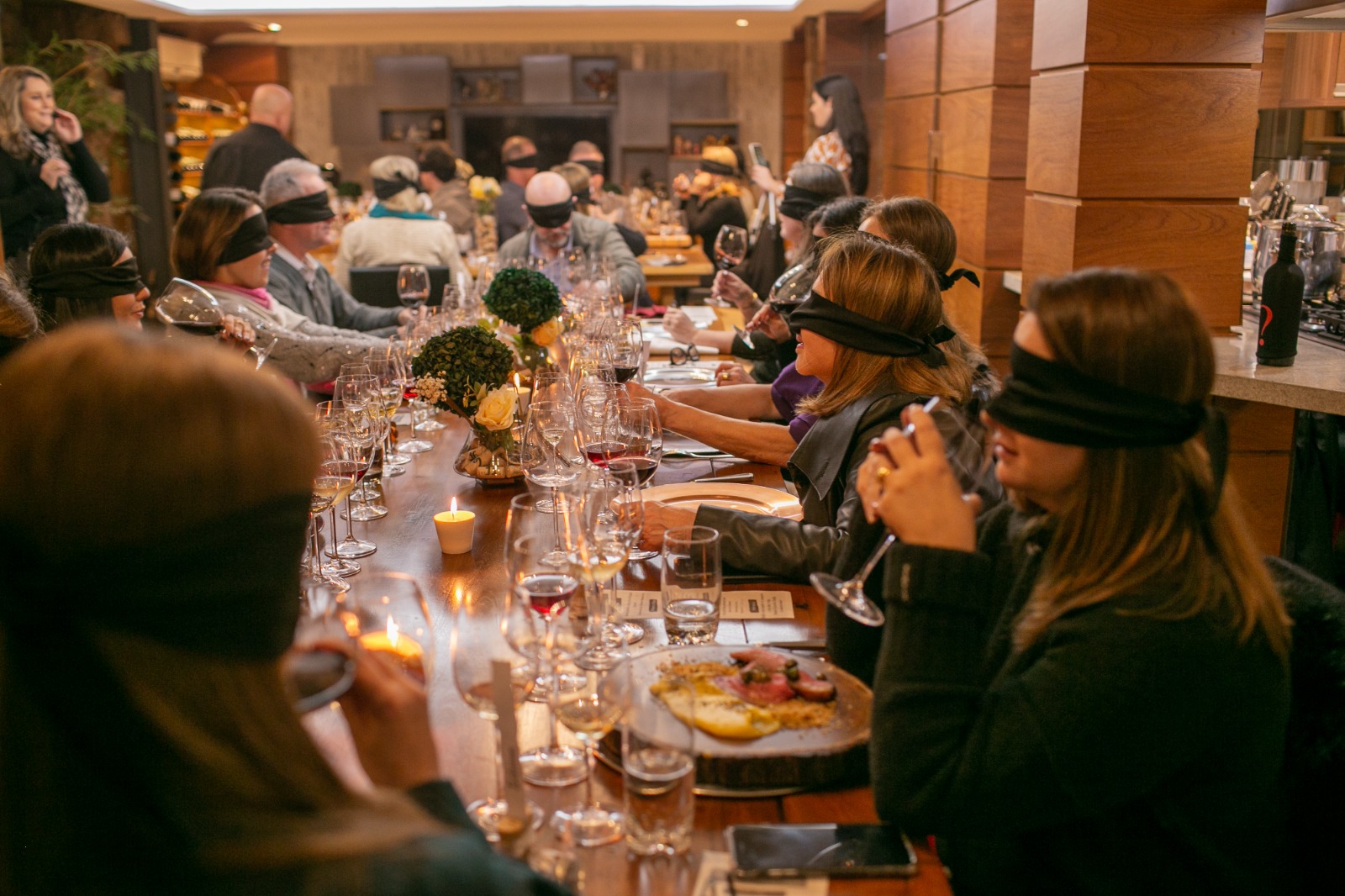 Experiência sensorial da AMO VINHO com convidados reunidos ao redor da mesa